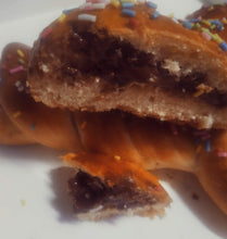 Cargar imagen en el visor de la galería, En la fotografía se aprecia la mona de pascua partida, y se ve el chocolate de su interior. Es un exquisito chocolate que fluye una vez se parte la mona. 
